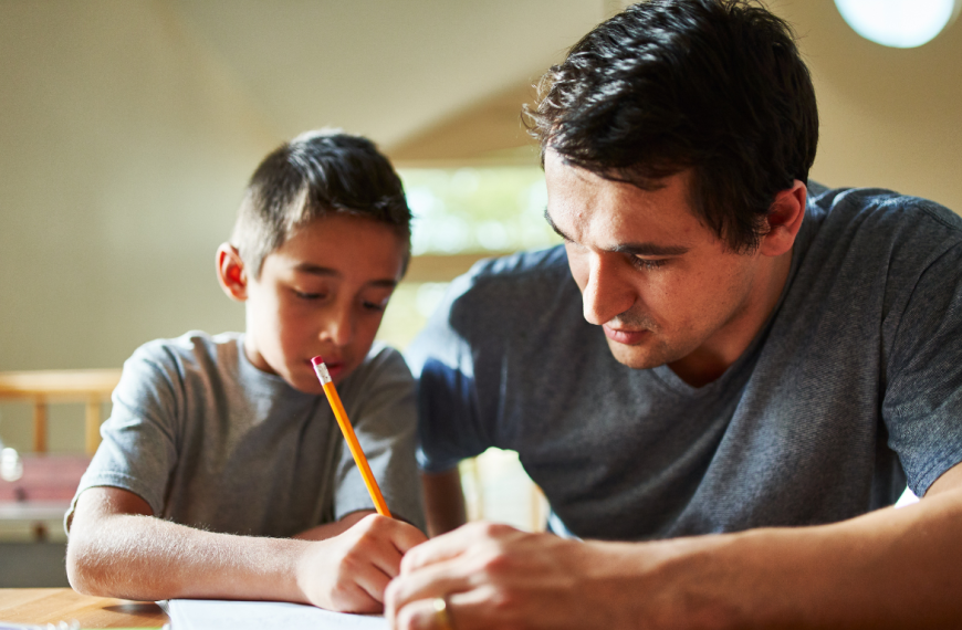 primary child supported in writing exercise.